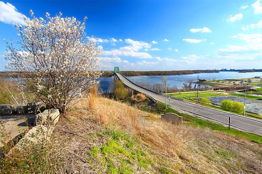 Muscatine IA - View of an Empty Bridge Across the River Surrounded by Grass and Blooming Foliage in Muscatine Iowa