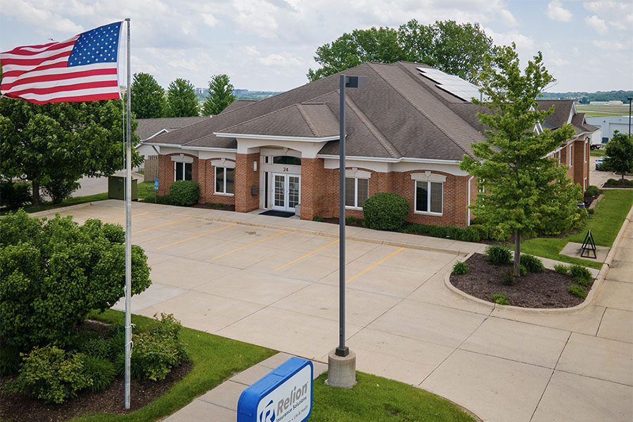 About Our Agency - View of Relion Insurance Solutions Office Building with an Empty Parking Lot and Green Landscaping